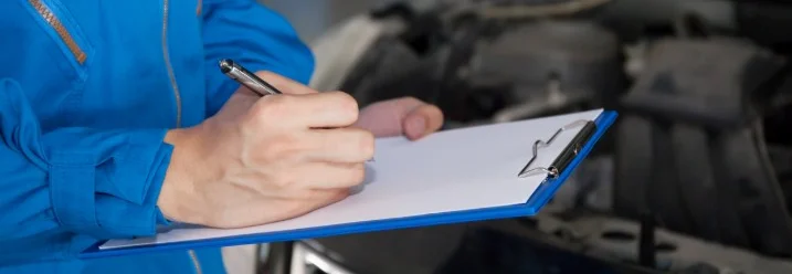 Person schreibt auf Klemmbrett